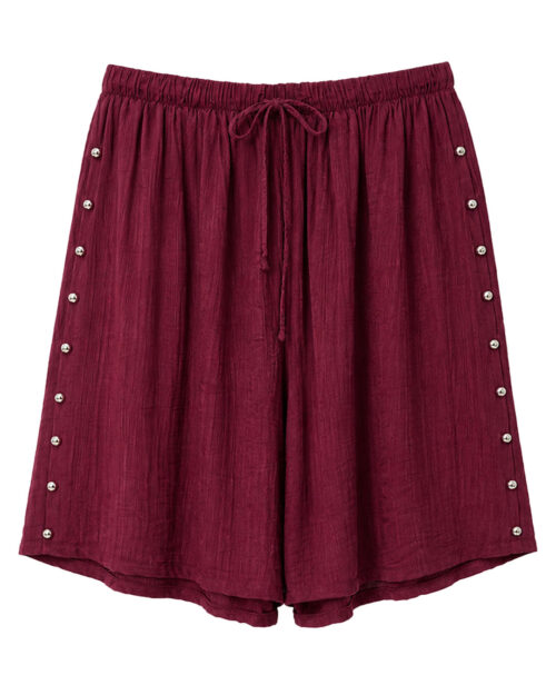 Bermuda Tachas: bermuda de diario color burdeos en tejido suave con textura, bolsillos, cintura elástica con cordón y detalles de tachuelas laterales de Quiles_Shop.
