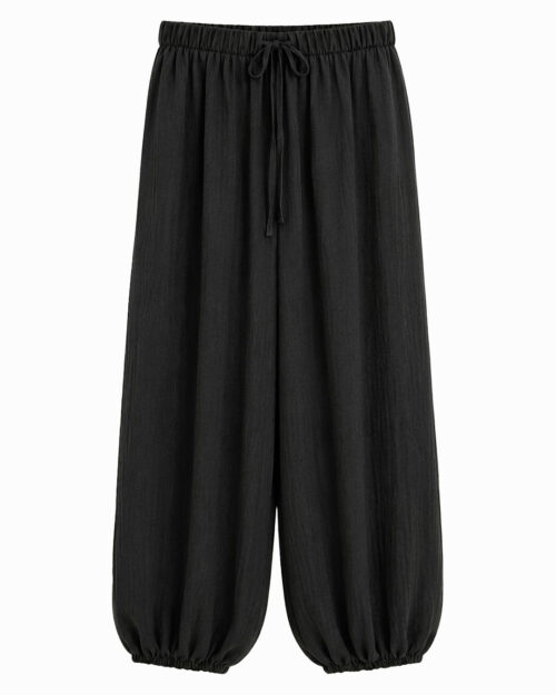 Pantalón Bombacho Ibiza: pantalón holgado negro en tejido fluido de viscosa elástica con cintura y tobillos elásticos de Quiles_Shop.